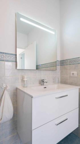 a bathroom with a white sink and a mirror at Sunset Bungalow Ocean View Palm Mar in Palm-Mar