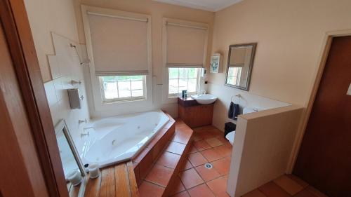La grande salle de bains est pourvue d'une baignoire et d'un lavabo. dans l'établissement Mendrinas at Brooklyn, à Tumut