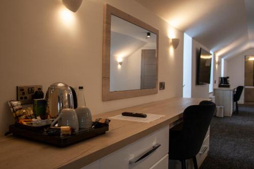 eine Küchentheke mit einem Waschbecken und einem Spiegel in der Unterkunft The Craven Heifer Inn in Kelbrook