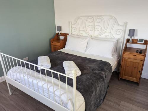 a bedroom with a white bed and a night stand at The Studio @ Cleeve Hill in Bath