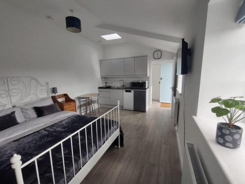 1 Schlafzimmer mit einem großen Bett und einer Küche in der Unterkunft The Studio @ Cleeve Hill in Bath