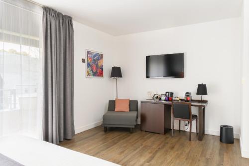 a hotel room with a desk and a television at Hype Hôtel in Biscarrosse