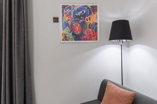 a living room with a couch and a lamp at Hype Hôtel in Biscarrosse