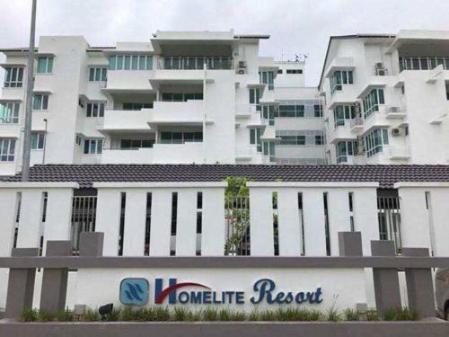 a large white building with a sign in front of it at Homelite Resort in Miri