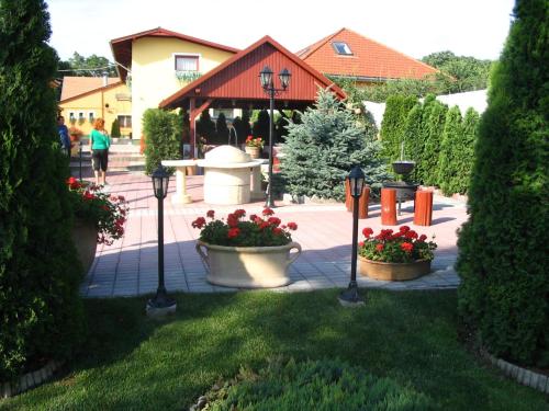 a garden with flowers in pots in a yard at Halász Airport Panzio in Vecsés