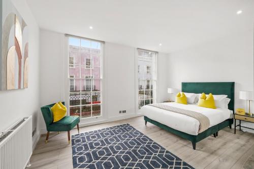 1 dormitorio blanco con 1 cama y 1 silla verde en Hububb Luxury Knightsbridge Apartments, en Londres