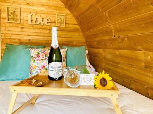 a bottle of wine sitting on a table on a bed at Lykke SUITE SPA SAUNA PISCINA Y JARDIN in Buzanada