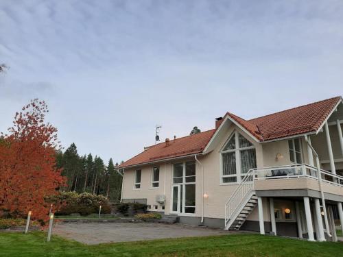 uma grande casa branca com um alpendre e escadas em Villa Kilpäkki em Pori