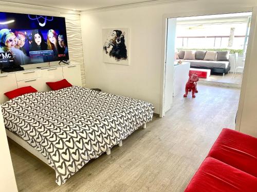 a bedroom with a bed and a tv on the wall at Magnifique appartement les pieds dans l’eau à Nice in Saint-Laurent-du-Var