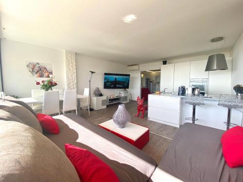 a living room with a couch and a kitchen at Magnifique appartement les pieds dans l’eau à Nice in Saint-Laurent-du-Var