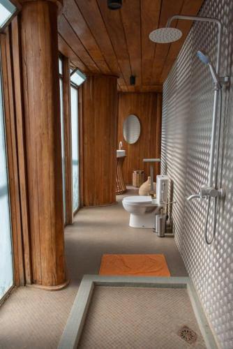 a large bathroom with a shower and a sink at Bâtiment Ovale in Toubab Dialaw