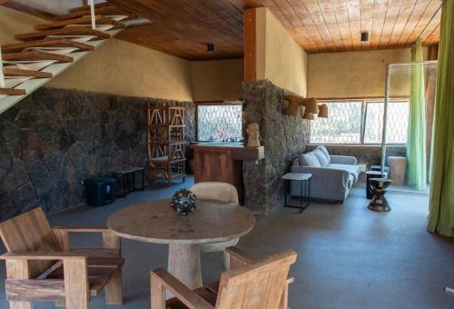 a living room with a table and a stone wall at Bâtiment Ovale in Toubab Dialaw