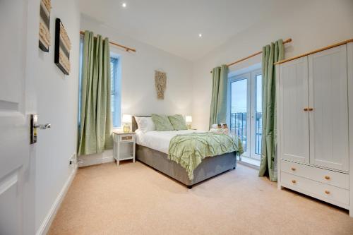 a bedroom with a bed and a large window at Armstrong Apartments by Week2Week in Newcastle upon Tyne