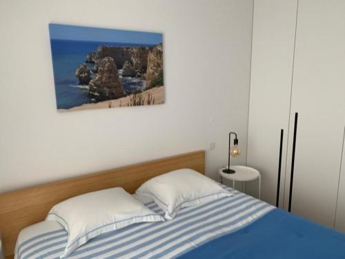 una camera con un letto con una foto sul muro di Ocean View Top Luxury New Built T2 -WPOV2 a Cabanas de Tavira