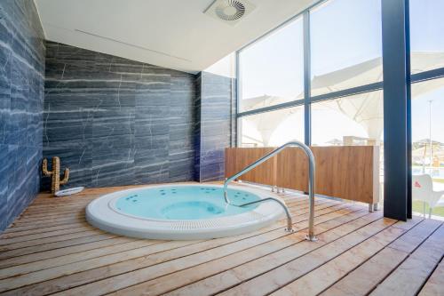 a jacuzzi tub in a room with a large window at Exe São Lázaro in Bragança