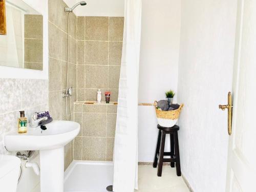 a white bathroom with a sink and a shower at Macaronesia Love Spa, sauna y piscina in Buzanada