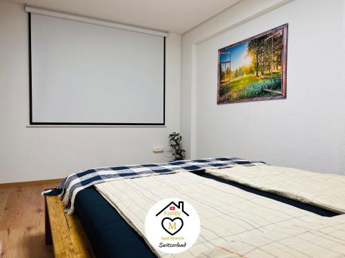 sypialnia z łóżkiem z obrazem na ścianie w obiekcie Family M Apartments 2-3-4 w mieście Kappel bei Olten