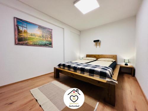 1 dormitorio con 1 cama y una pintura en la pared en Family M Apartments 2-3-4, en Kappel bei Olten