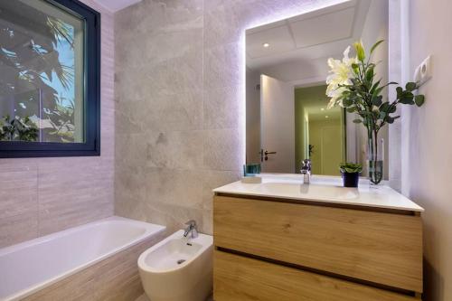 y baño con lavabo, bañera y espejo. en Luxury 2bed apartment Mirador del Golf, Estepona, en Estepona