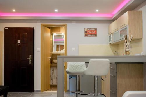 a kitchen with a counter and a pink lighting at Gogolapartman Tisza in Szeged