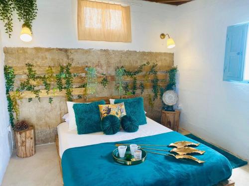 a bedroom with a bed with a blue blanket at Laurisilva love spa sauna y piscina in Buzanada