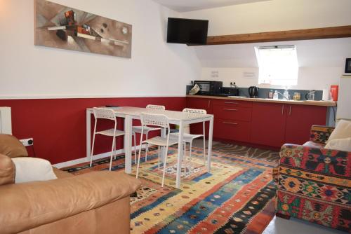 a living room with a table and a kitchen at Appartement 3 chambres, Camping La Pointe in Châteaulin