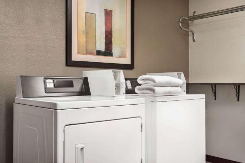 a bathroom with a washer and dryer and towels at Travelodge by Wyndham Yuma in Yuma