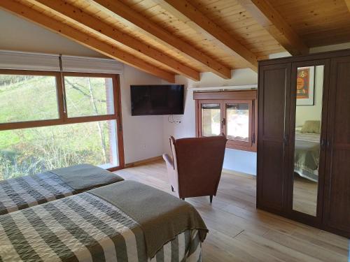 1 dormitorio con 1 cama y TV de pantalla plana en Balcón del Aitzgorri, en Mutiloa