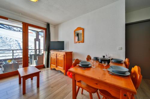une salle à manger avec une table avec des chaises et une télévision dans l'établissement Le Petit Flocon - Appt pour 6 vue sur piste, à Villarembert
