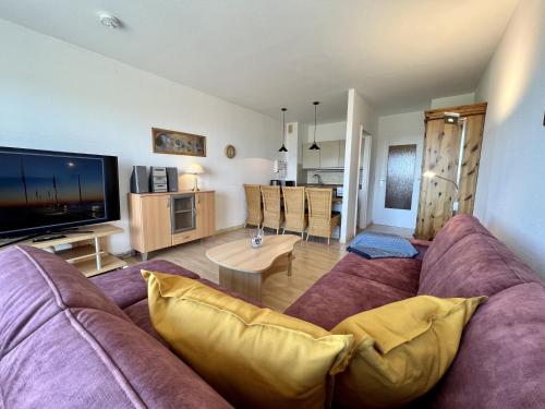 a living room with a couch and a tv at Haus am Deich Wohnung 10 in Dahme