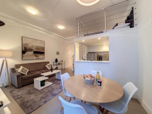 un salon avec une table, des chaises et un canapé dans l'établissement Nestor&Jeeves - LES CYPRES - central - very close sea, à Nice