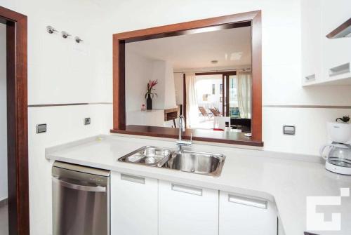 una cucina con lavandino e specchio di Villa Mirador de Bassetes 4 - Grupo Turis a Calpe