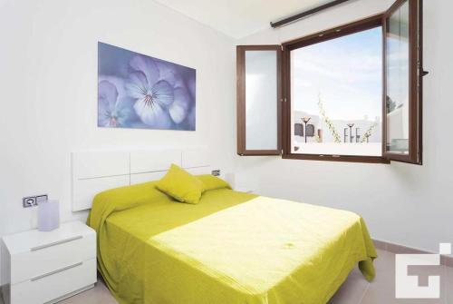 Un dormitorio con una cama amarilla y una ventana en Villa Mirador de Bassetes 4 - Grupo Turis, en Calpe