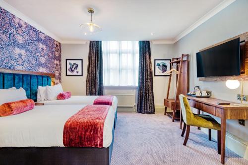 a hotel room with two beds and a desk at The Hand & Sceptre by Innkeeper's Collection in Southborough