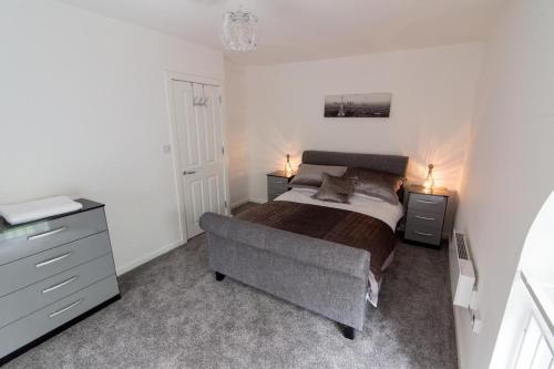 een slaapkamer met een bed en een dressoir bij Nazarene apartments in Leeds in Stanningley
