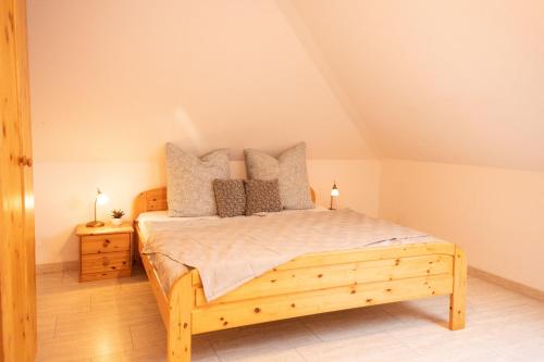 a bedroom with a wooden bed with pillows on it at Tillmann II in Hooksiel mit Hund in Wangerland