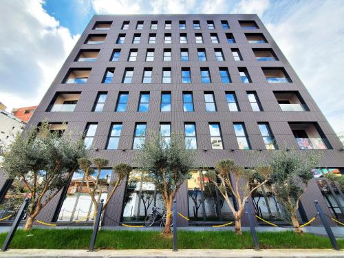 un edificio alto con alberi di fronte di StarLight Hotel a Tirana