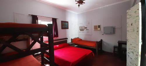 Habitación con 2 literas y sofá rojo. en Pequeña Estación B&B en Mendoza