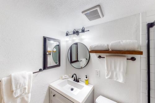 La salle de bains blanche est pourvue d'un lavabo et d'un miroir. dans l'établissement Shredders and Hikers Delight Full Property, à Vail