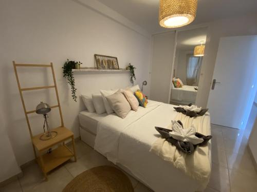 Un dormitorio con una gran cama blanca y un espejo. en Love in the Sea Viña del Mar by Deihu Experiences, en Adeje