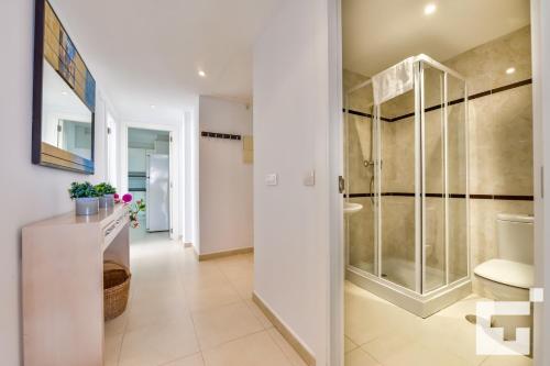 a bathroom with a glass shower and a toilet at Apartamento Apolo XIX 34L - Grupo Turis in Calpe