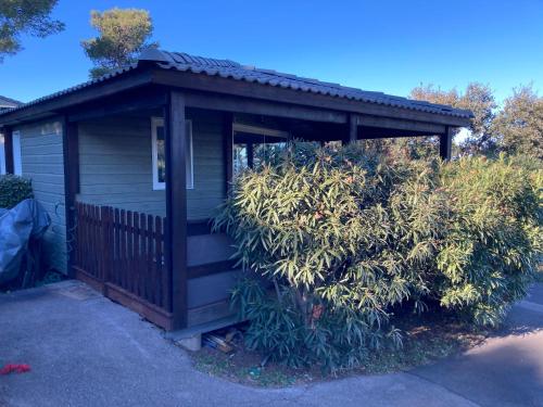 a small house with a porch and a bush at Le cap d Agde Chalet les pescalunes - vue mer in Agde