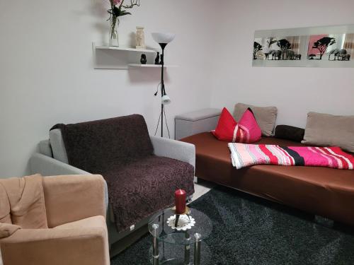 a living room with a couch and a chair at Ferienwohnungen am Krossinsee in Berlin