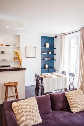 un salon avec un canapé violet et une table dans l'établissement Newly Remodeled 2Bed APT with Elevator - Mobility Lease for Students and Work ONLY- Minimum 30 night stays, à Paris