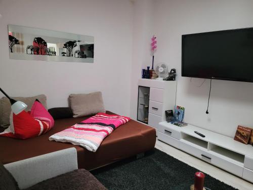 a living room with a couch and a flat screen tv at Ferienwohnungen am Krossinsee in Berlin
