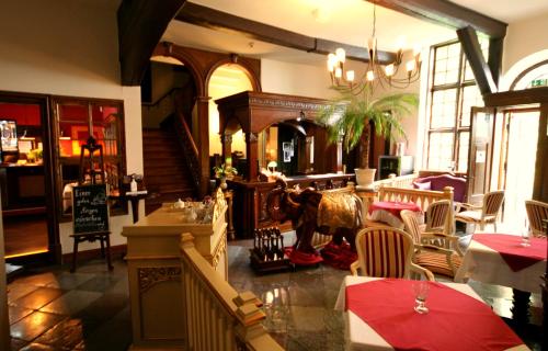 ein Esszimmer mit einem Tisch und Stühlen sowie ein Restaurant in der Unterkunft Hotel Denkmal 13 Rostock - Kaufmannshaus Krahnstöver in Rostock