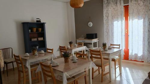 uma sala de jantar com mesas e cadeiras e uma janela em B&B Margherita em Bagheria