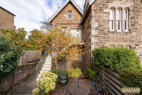 a brick house with a staircase leading up to it at Seascape in North Berwick