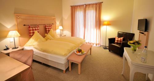 a bedroom with a large bed and a living room at Landgasthof Mücke in Marsberg