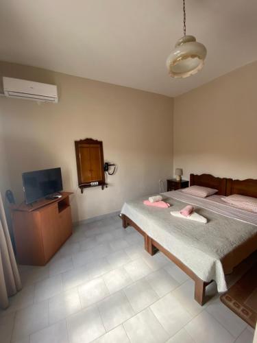 um quarto com duas camas e uma televisão em Casa Helen em Limín Iérakos